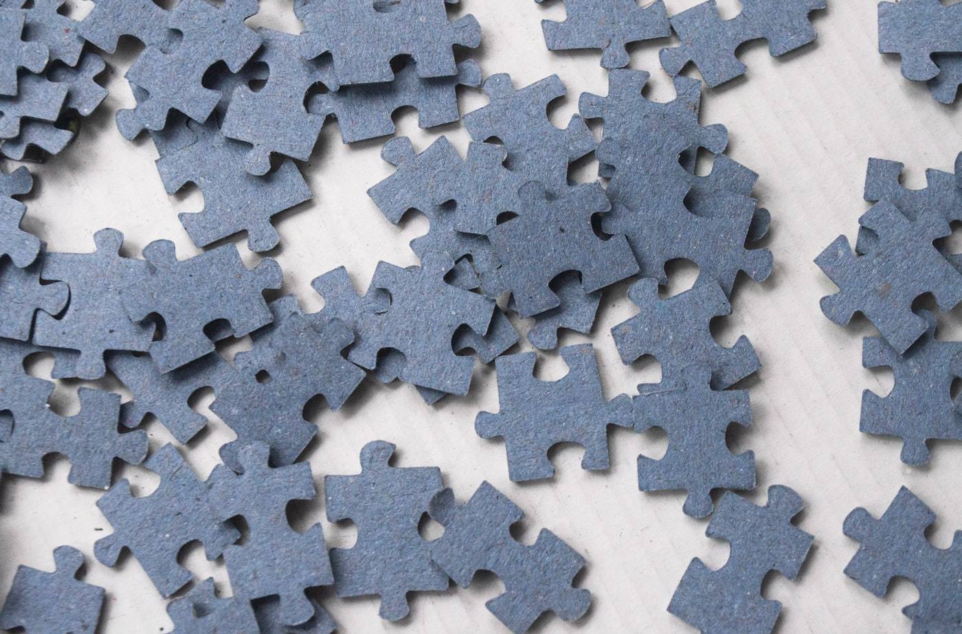 Jigsaw puzzle pieces scattered across a pale surface