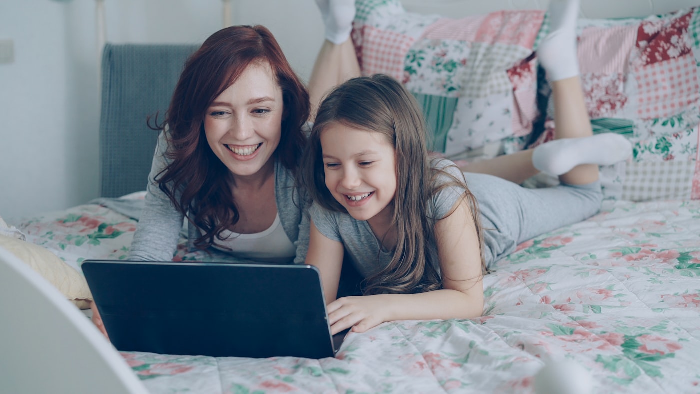A parent and child looking at a laptop screen together